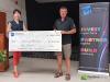 two people stand with a giant cheque between them 