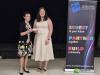 One woman presents a cheque to another 