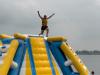 a person raises their hands on an inflatable water park