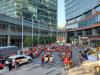 A HIGH AND WIDE ANGLE SHOT OF A LARGE CROWD SPREAD THROUGHOUT TRUE NORTH SQUARE VISITING AND SITTING AT PICNIC TABLES